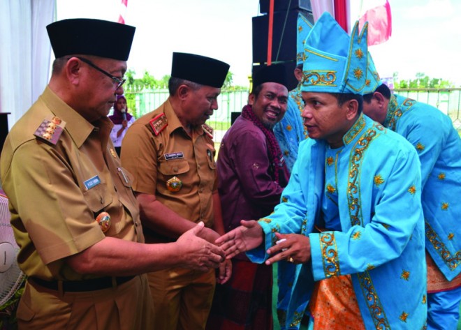 Bupati memberi selamat kepada kades yang dikukuhkan jadi pemangku adat.